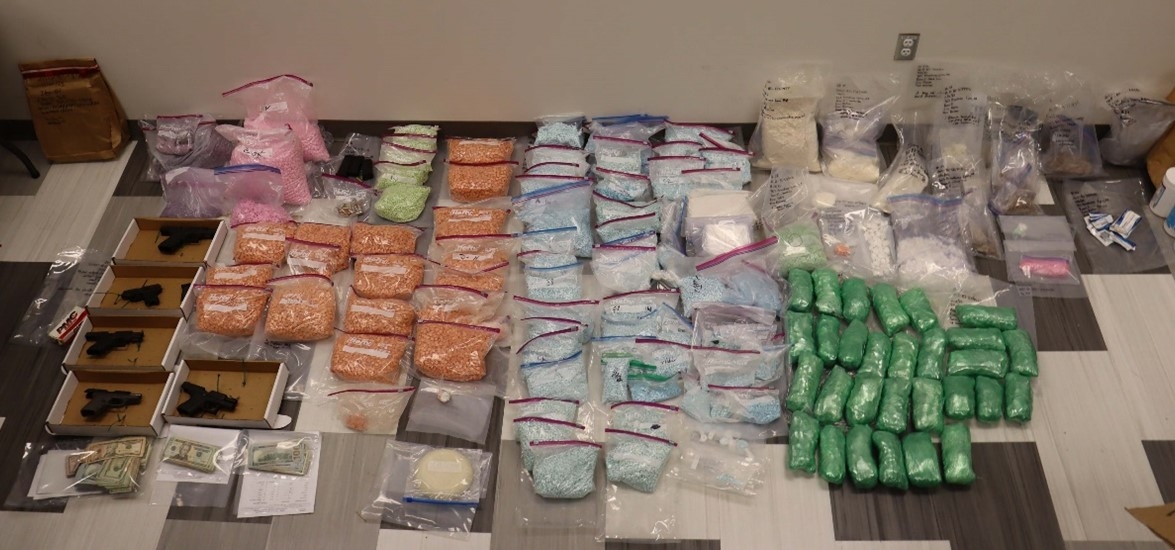 piles of guns, drugs and money that were sized 