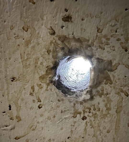 Photo depicting hole in jail wall