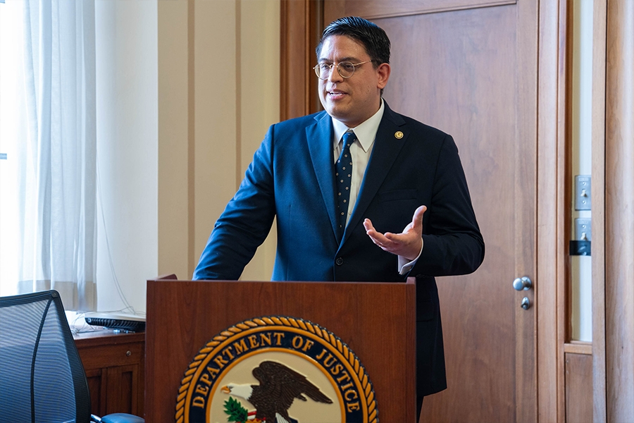 Principal Deputy Assistant Attorney General for Civil Rights Jesus Osete delivers remarks from a podium at the Justice Department. He is joined by friends, family members, and colleagues.