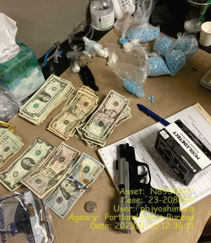 Seized firearm, fentanyl pills, and cash.  