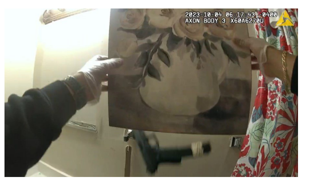 Behind a canvas painting which hung above a bathroom toilet, officers recovered a .40 caliber Glock semi-automatic handgun with an extended magazine. As they removed the canvas, the loaded firearm fell onto the toilet tank.