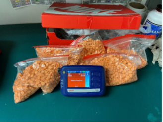 multiple plastic baggies containing orange pills