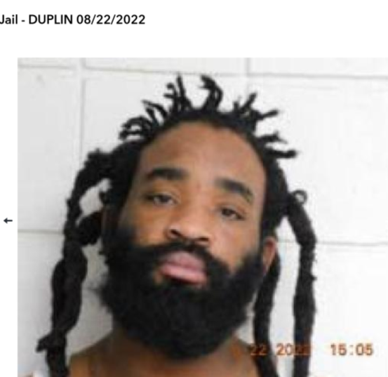 Photo of man with beard in front of concrete background