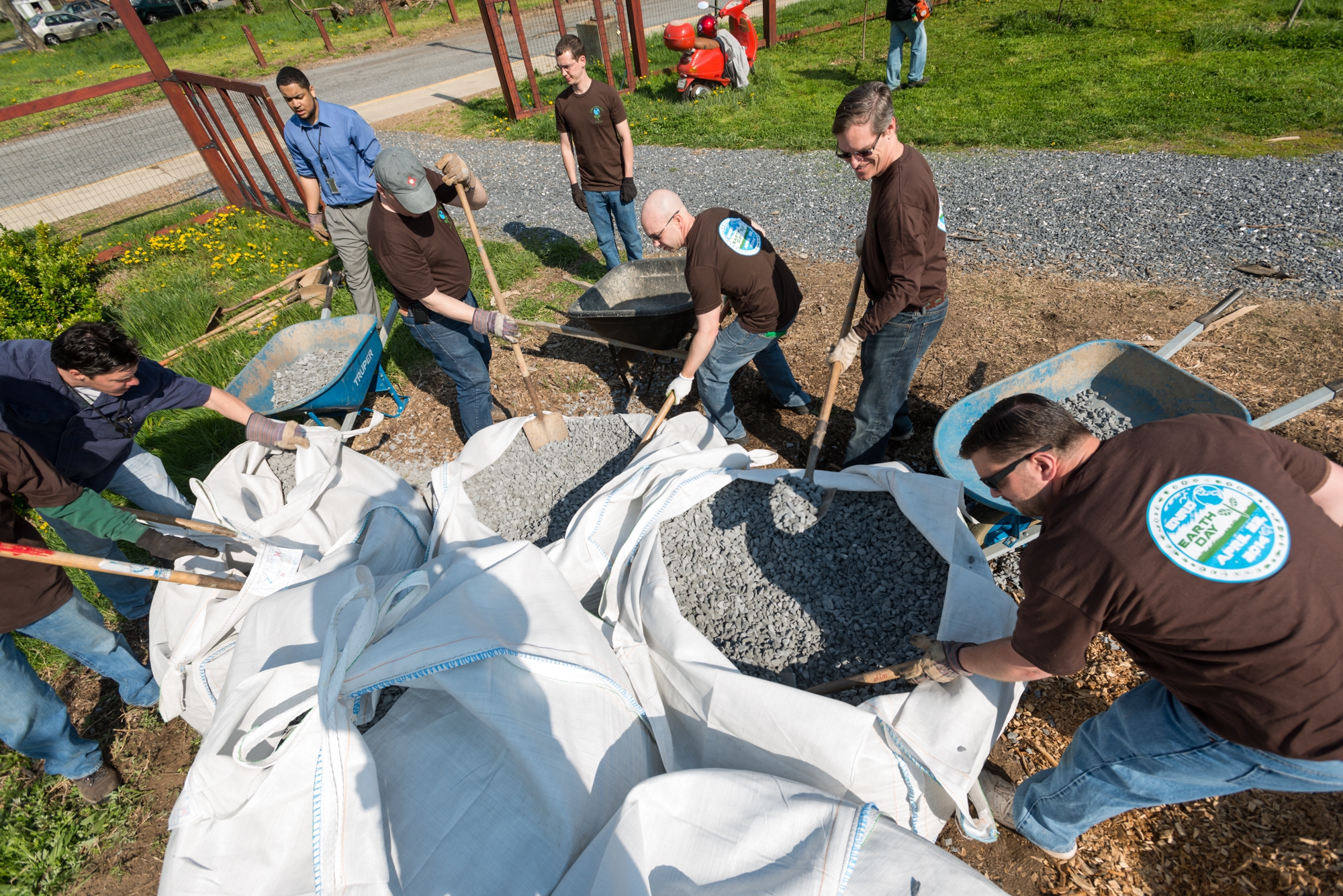 ENRD volunteers shoveling gravel into wheelbarrows
