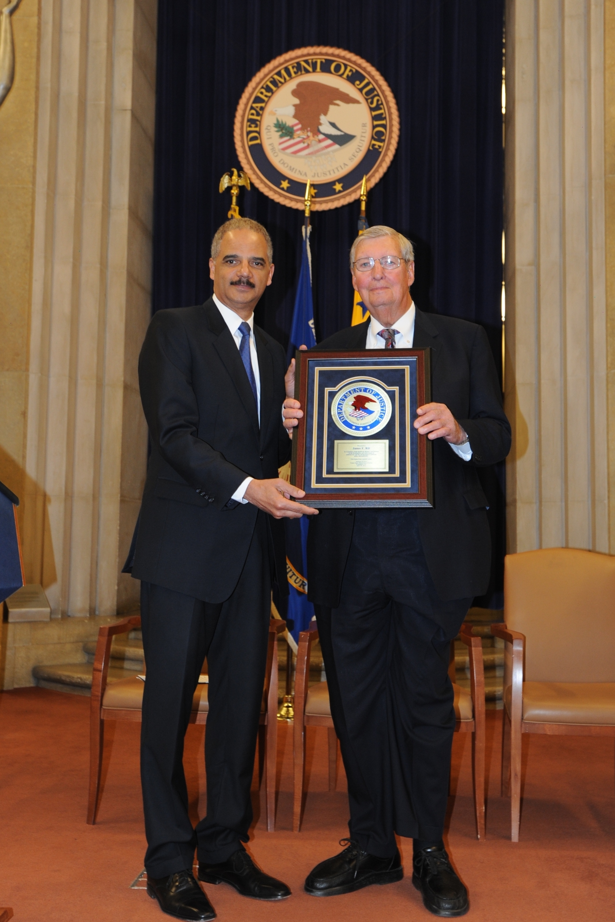 Attorney General Eric Holder honors former Assistant Attorney General James F. Rill with the 2012 Sherman Award.
