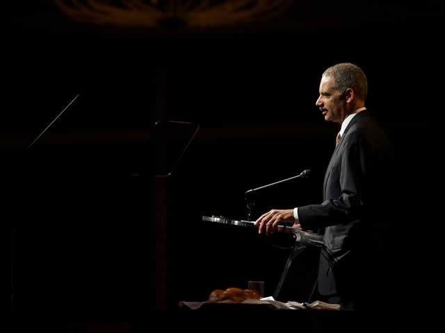 The Attorney General at the podium joining survivors of the Holocaust during the Days of Remembrance.