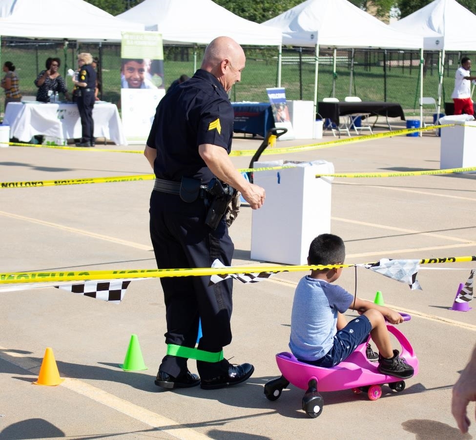 Federal and State Law Enforcement interact with toddlers on the race track.