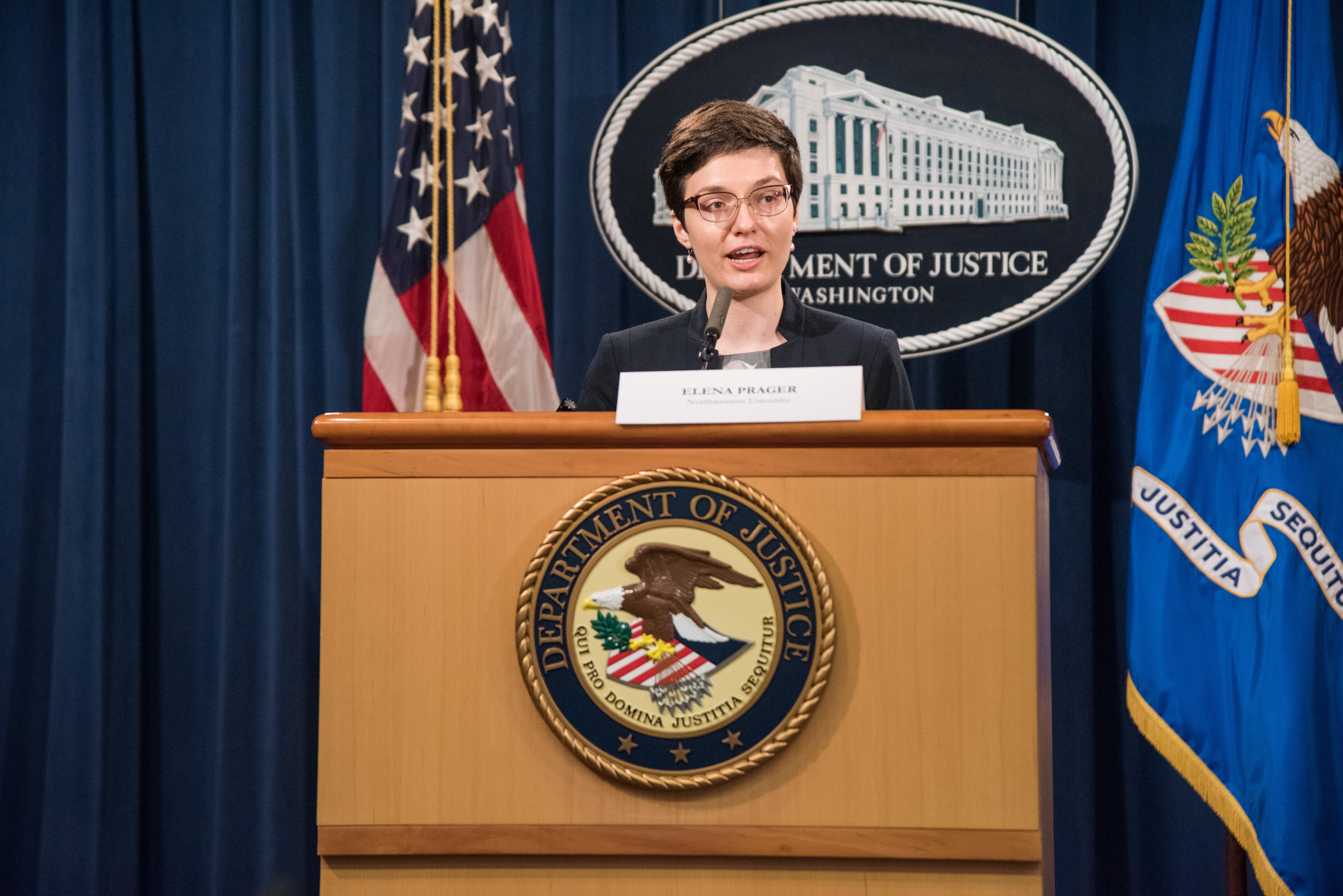 Elena Prager speaking at a podium at the Competition in Labor Markets Workshop