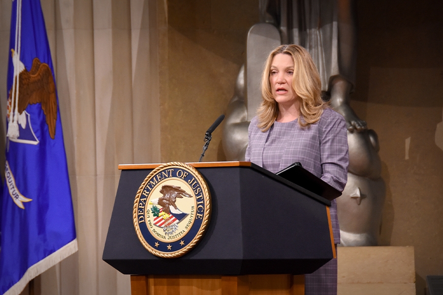 Health and Human Services Deputy Secretary Andrea Palm speaks at a podium with the Department of Justice seal.