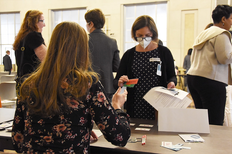 A woman participates in the Reentry Simulation, going through the process of obtaining public transportation tickets.