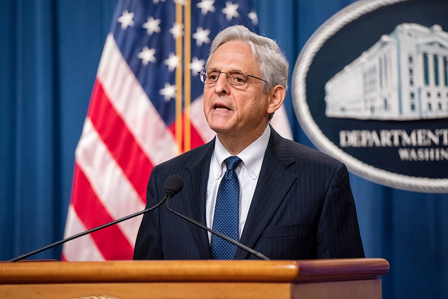 Attorney General Merrick B. Garland speaks at a podium bearing the Department of Justice seal.