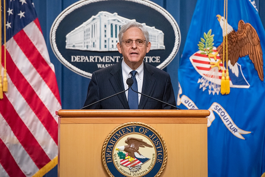 Attorney General Merrick B. Garland speaks at a podium bearing the Department of Justice seal.