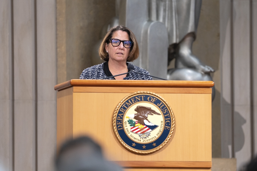 Deputy Attorney General Lisa O. Monaco delivers remarks at a podium in the Robert F Kennedy Main Justice Building’s Great Hall.