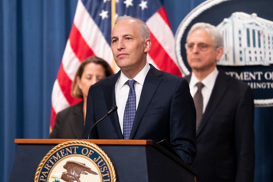 Assistant Attorney General Matthew G. Olsen of the Justice Department’s National Security Division delivers remarks from a podium bearing the Department of Justice seal.