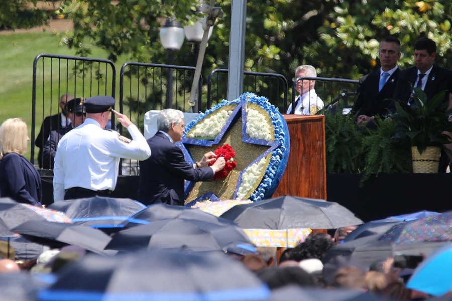 Attorney General Garland places a red flower within a large star as part of the Annual National Peace Officers’ Memorial Service.