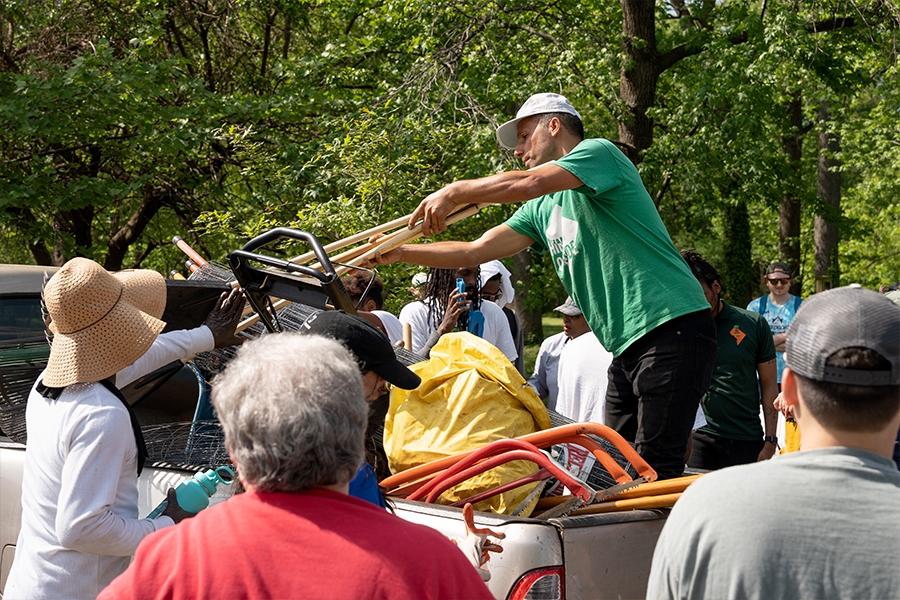 Sites Manager Behnam Mehrabkhani hands out yardwork tools to volunteers.