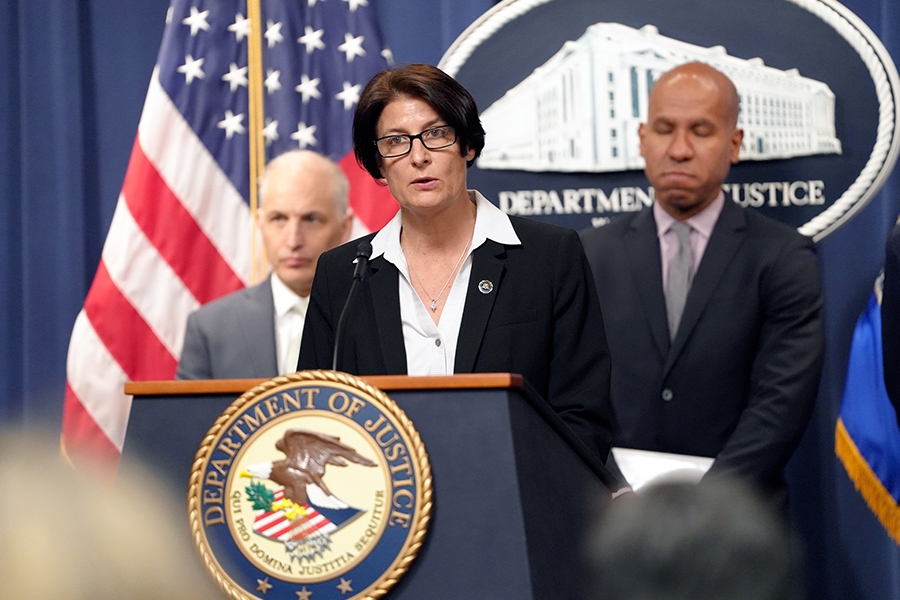 Assistant Director Suzanne Turner of the FBI's Counterintelligence Division delivers remarks from a podium bearing the Department of Justice seal.