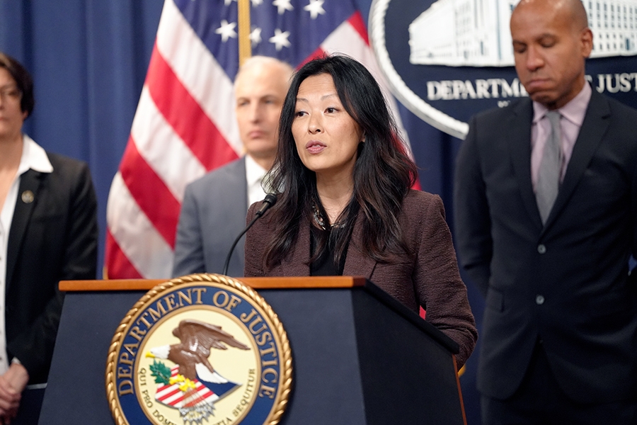 Department of State Deputy Special Representative for the DPRK Dr. Jung Pak delivers remarks from a podium bearing the Department of Justice seal.