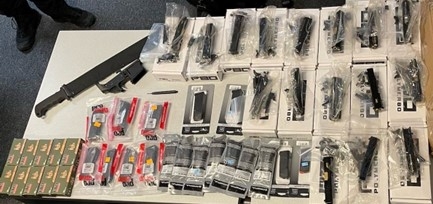 Photograph of items seized from Burroughs, including ghost gun kits, magazines, and a machete