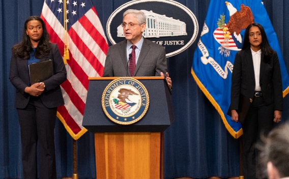 Attorney General Merrick B. Garland delivers remarks from a podium bearing The Department of Justice seal.