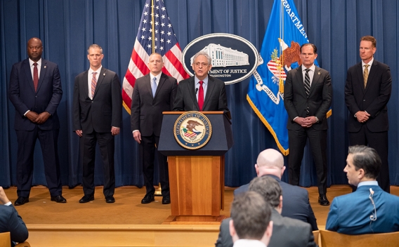 Attorney General Merrick B. Garland delivers remarks from a podium bearing the Department of Justice seal.