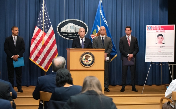 Assistant Attorney General Matthew G. Olsen addresses reporters from a podium at the Department of Justice