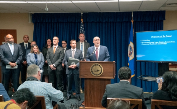 Attorney Andrew M. Luger from the U.S. Attorney’s Office for the district of Minnesota speaks at a podium bearing the Department of Justice seal.