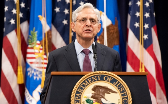 Attorney General Merrick Garland addresses the audience at the Department of Justice from a podium bearing the Department of Justice seal