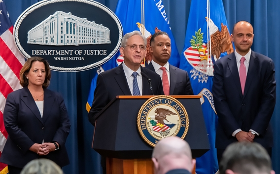 Attorney General Merrick B. Garland delivers remarks from a podium bearing the Department of Justice seal