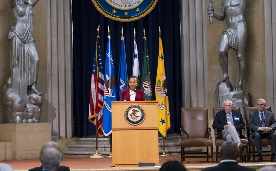 Assistant Attorney General for Civil Rights Kristen Clarke delivers remarks at a podium in the Robert F Kennedy Main Justice Building’s Great Hall.