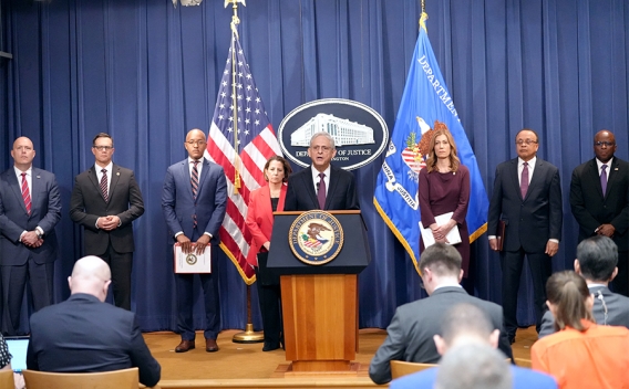 Attorney General Merrick B. Garland delivers remarks from a podium bearing the Department of Justice seal.