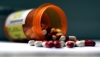 red and white pills spilling out of a pill bottle red and white pills spilling out of a pill bottle
