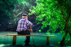 Elderly man sitting next to a river