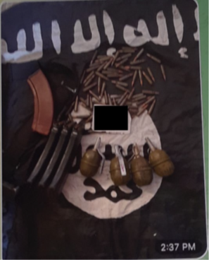 An image of ammunition, and grenades on top of an ISIS flag.  