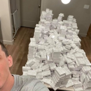 Defendant, Nicholas Frank Sciotto, taking a quasi-selfie with counterfeit COVID-19 vaccination cards in the background.