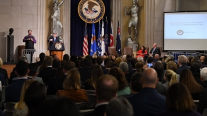 Attorney General William Barr speaking at a podium at the Lawful Access Summit