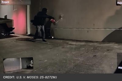 Image of suspect pouring gasoline on building.