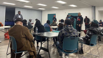 Darryl Woods, CEO of Fighting the Good Fight speaks with a group of justice-impacted residents