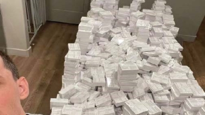 Picture of side of defendant's face, neck and shoulder taking a selfie  with a stack of COVID-19 fake vaccination record cards behind him. 
