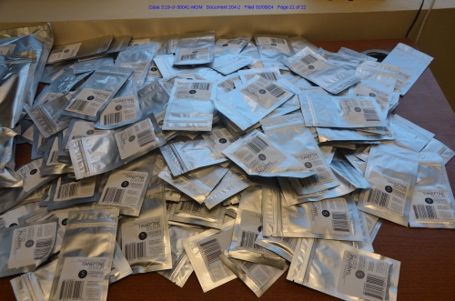 Pile of white resealable packets containing drugs on a table 