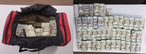 Black and red duffle bag filled with money and stacks of money on a table