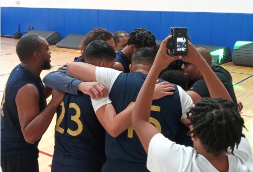 Members of the U.S. Attorney’s Office for the Southern District of Florida basketball team take a quick huddle to design a play during the recent Fall Classic Youth & Cops Basketball Tournament