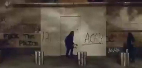 Gaines outside courthouse barricade with hammer in right hand