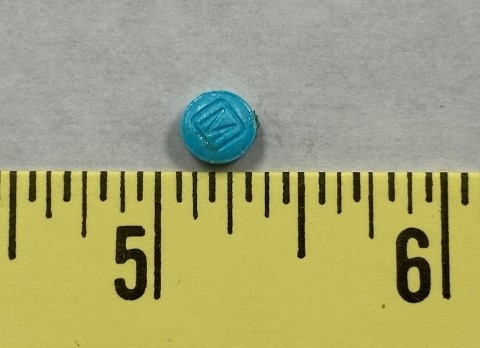 Blue pill next to measuring tape for size-Counterfeit Oxycodone (M-30) Seized in Jackson County