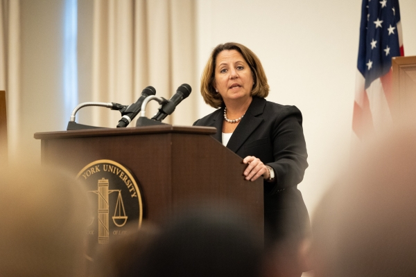 Deputy Attorney General Monaco Delivers Remarks on Corporate Criminal Enforcement Deputy Attorney General Monaco stands at a podium