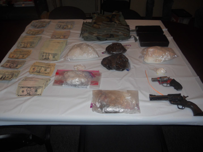 Guns, drugs, and cash found in the residence.