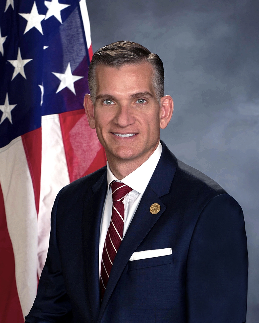 U.S. Attorney Bobby L. Christine in front of flag