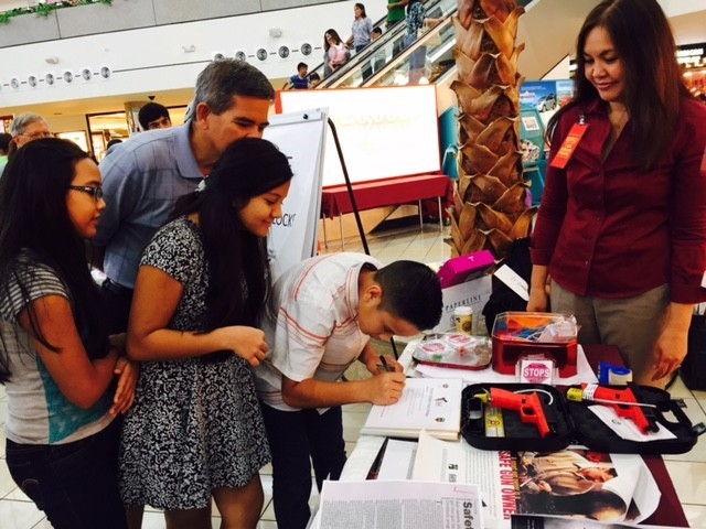 Picture of U.S. Attorney Alicia Limtiaco looking on as students take the pledge on gun safety