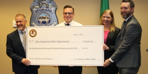4 people holding a large check for the Spokane Police Department 