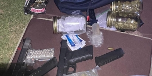 Photo of firearms and drugs on ground